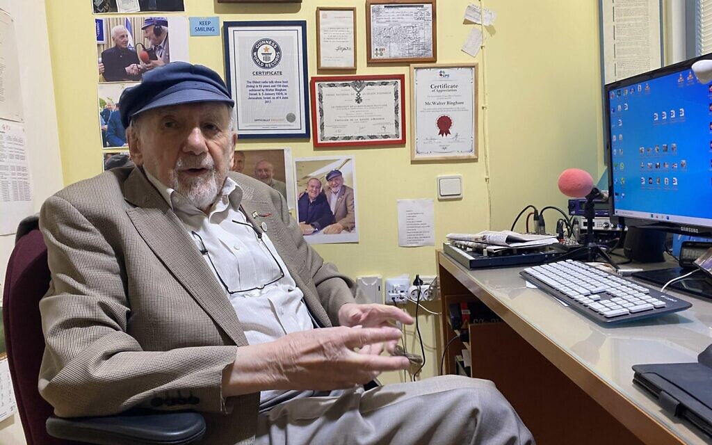 Longtime radio journalist Walter Bingham sits in his office behind a wall filled with memorabilia, including a telegram regarding an award he won from the United Kingdom's King George VI. (Sam Sokol/ JTA)