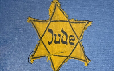 FILE - In this file photo from January 22, 2014, the Yellow Star badge of Heinz-Joachim Aris (Dresden 1941) reading 'Jew' is displayed in a showcase during a press preview in the new special exhibition 'Shoes of the Dead - Dresden and the Shoah' at the Military History Museum in Dresden, Germany. (AP Photo/Jens Meyer, file)