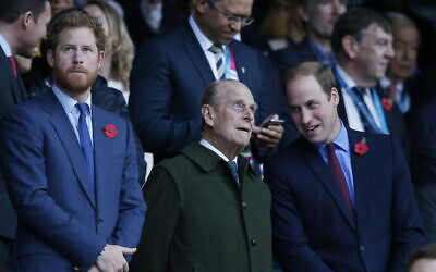 Britain's Prince Harry, left, and his brother Prince William, right, stand with their grandfather the Duke of Edinburgh as they wait for the start of the Rugby World Cup final between New Zealand and Australia at Twickenham Stadium, London, October 31, 2015. (AP Photo/Alastair Grant, File)