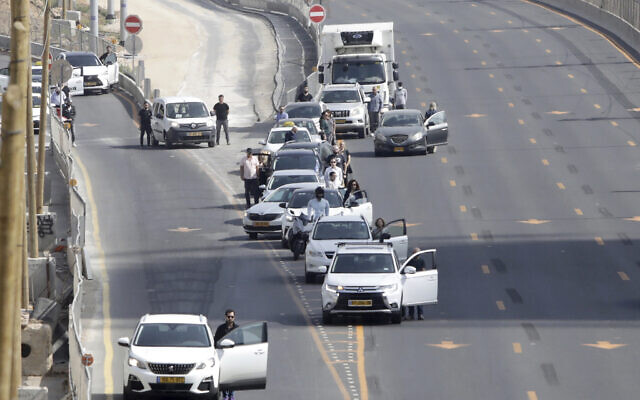 Israelis stand next to their cars as sirens mark a nationwide moment of silence in remembrance of the 6 million Jewish victims of the Holocaust, in Tel Aviv, Israel, April 8, 2021. (AP Photo/Sebastian Scheiner)