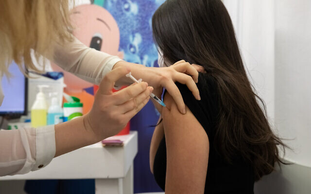 A young Israeli receives a COVID-19 vaccine injection, at a Clalit vaccination center in Holon, February 4, 2021. (Chen Leopold/Flash90)