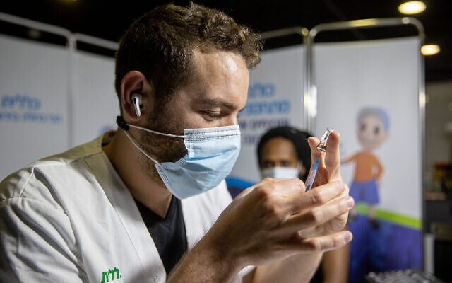 A health worker prepares a COVID-19 vaccine shot at a vaccination center in Jerusalem, on March 11, 2021. (Yonatan Sindel/Flash90)