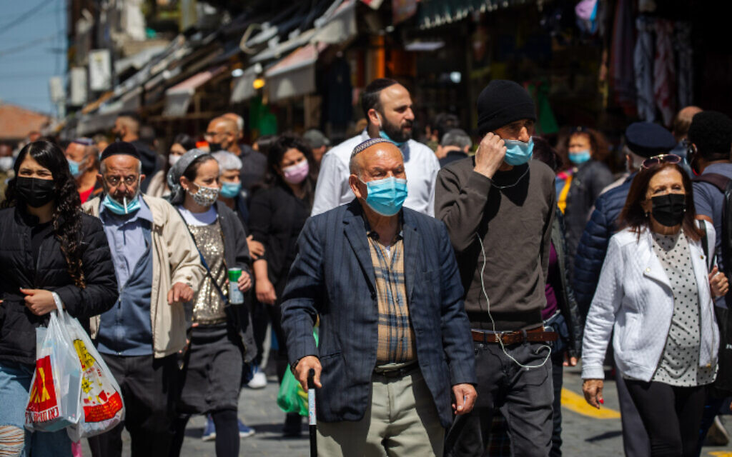 People wearing face masks shop at the Mahane Yehuda market in Jerusalem on March 17, 2021 (Olivier Fitoussi/Flash90)
