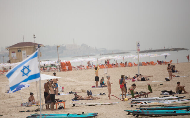 Israelis enjoy the beach in Tel Aviv on a hot spring day, April 19, 2021 (Miriam Alster/FLASH90)