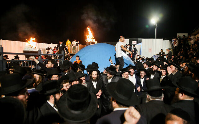 Crowds of ultra-Orthodox Jews celebrate the lighting of a bonfire during the celebrations of the holiday of Lag B’Omer on Mt. Meron in northern Israel on April 29, 2021. (David Cohen/Flash90)