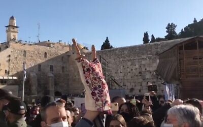 Screen capture from video of a Torah scroll brought by Labor MK Gilad Kariv to the Western Wall for use in a women's prayer group is held aloft, April, 14, 2021. (Israel Hayom)