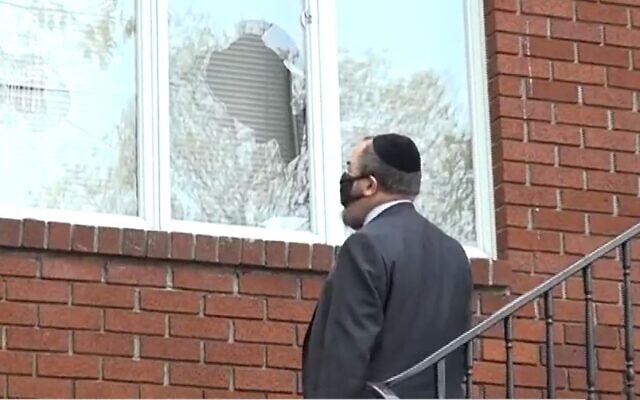 A US rabbi inspects the damage at the Chabad of Riverdale synagogue after vandals broke windows of four neighborhood synagogues on April 25, 2021. (Screen capture/News12 Connecticut)