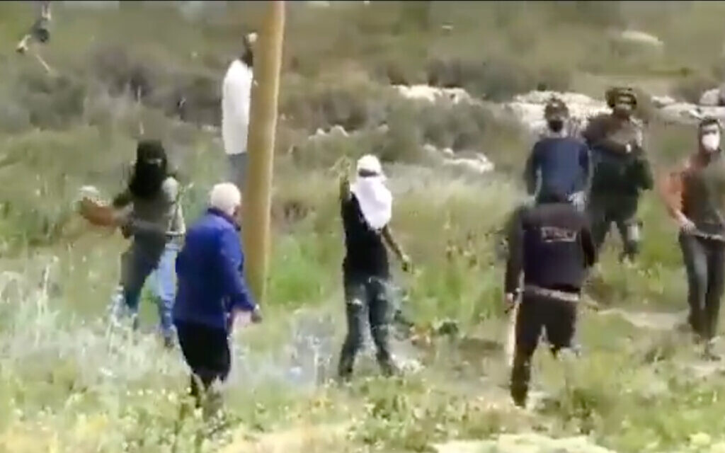 Settlers filmed throwing stones at a Palestinian man in the West Bank