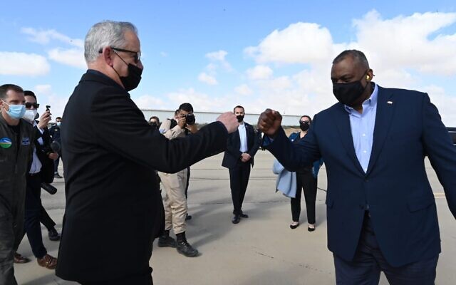 Defense Minister Benny Gantz, left, fist-bumps US Defense Secretary Lloyd Austin at the Nevatim Air Base in southern Israel on April 12, 2021. (Ariel Hermoni/Defense Ministry)