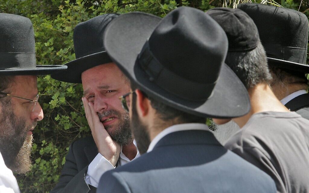 An ultra-Orthodox Jewish man weeps at a cemetery in Bnei Brak, during the funeral of one of the victims of the Meron crush on April 30, 2021. (GIL COHEN-MAGEN / AFP)