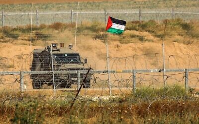 A Palestinian national flag is erected on the Israel-Gaza border, east of Khan Yunis town in the southern Gaza Strip, on May 8, 2021. (Said Khatib/AFP)