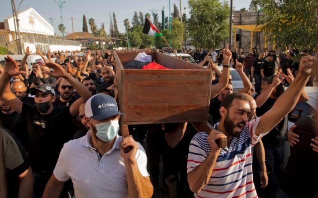 Arab Israelis gesture and wave Palestinian flags during the funeral of Mousa Hassouna in the central Israeli city of Lod near Tel Aviv, on May 11, 2021. Hassouna was killed during clashes with Israeli security following an anti-Israel demonstration over tensions in Jerusalem. (AFP)