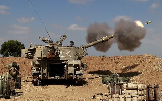 Israeli soldiers fire toward the Gaza Strip from their position near the southern Israeli city of Sderot