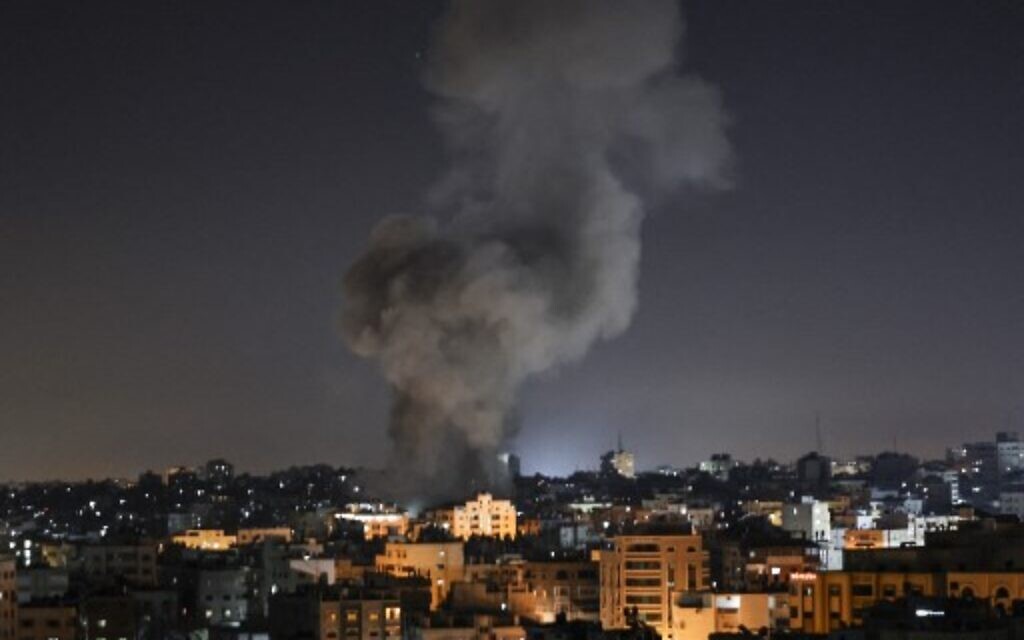 Smoke billows above buildings after an Israeli airstrike on Gaza City in the Gaza Strip early on May 15, 2021. (Photo by MAHMUD HAMS / AFP)