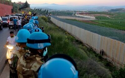 United Nations peacekeeping force in Lebanon (UNIFIL) soldiers stand along the border wall with Israel, in the Lebanese village of Adaiseh, on May 15, 2021. (Mahmoud Zayyat/AFP)