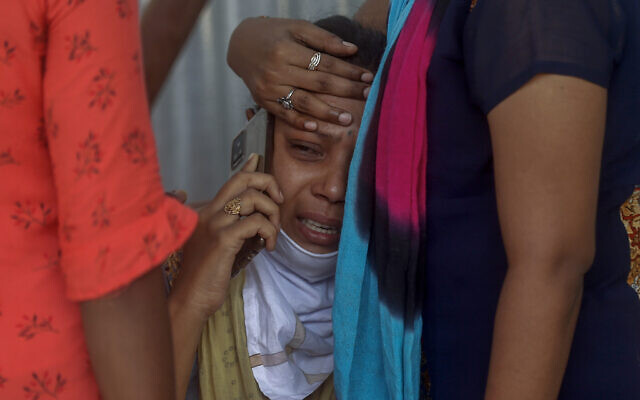 In this May. 3, 2021, file photo, relatives of a person who died of COVID-19 mourn outside a field hospital in Mumbai, India. COVID-19 infections and deaths are mounting with alarming speed in India with no end in sight to the crisis. People are dying because of shortages of bottled oxygen and hospital beds or because they couldn’t get a COVID-19 test. (AP Photo/Rafiq Maqbool, File)