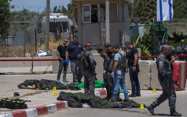 Israeli forces inspect the scene of a shooting attack where the bodies of two Palestinian gunmen, who were killed by Border Police after opening fire, lie on the ground in front of the military base of Salem near the West Bank town of Jenin, May 7, 2021. (AP Photo/Gil Eliyahu)