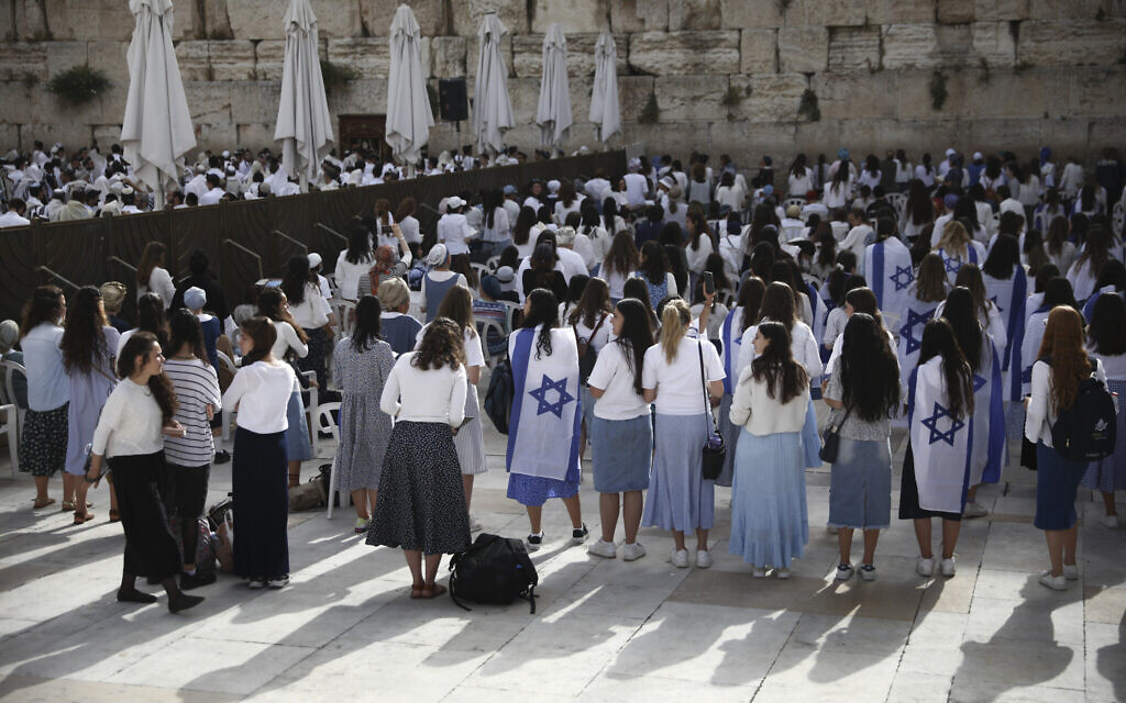 Jewish women, some covered with Israeli flags, pray during Jerusalem Day, an Israeli holiday celebrating the reunification of the city in the 1967 Six Day War, at the Western Wall, the holiest site where Jews can pray in the Old City of Jerusalem, May 10, 2021. (AP Photo/Oded Balilty)