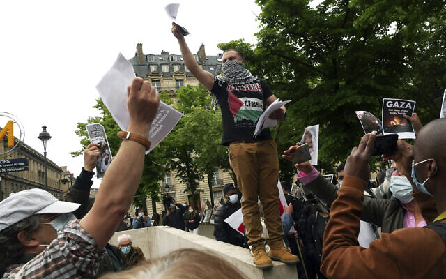A protester distributes leaflets during a protest in solidarity with Palestinians, in Paris, Wednesday, May 12, 2021. (AP Photo/Thibault Camus)