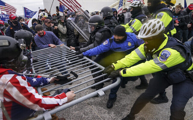 Supporters of then-President Donald Trump try to break through a police barrier, at the Capitol in Washington, January 6, 2021. (John Minchillo/AP)