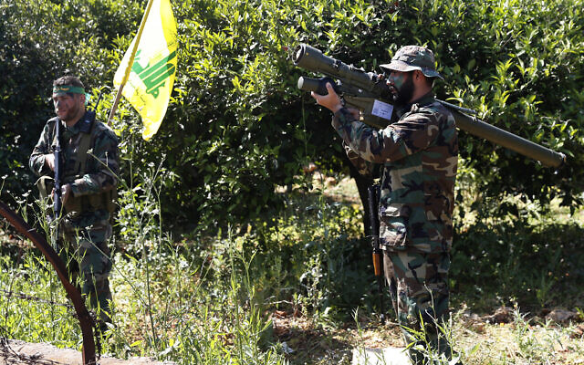 In this April 20, 2017 file photo, a Hezbollah fighter holds an Iranian-made anti-aircraft missile, right, as he takes his position with his comrade, left, between orange trees, at the coastal border town of Naqoura, south Lebanon.  (AP Photo/Hussein Malla, File)