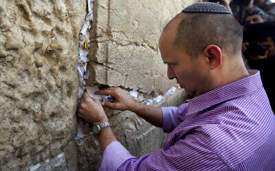 Naftali Bennett places a note in the stones of the Western Wall in Jerusalem's old city, January 21, 2013.  (AP Photo/Sebastian Scheiner)