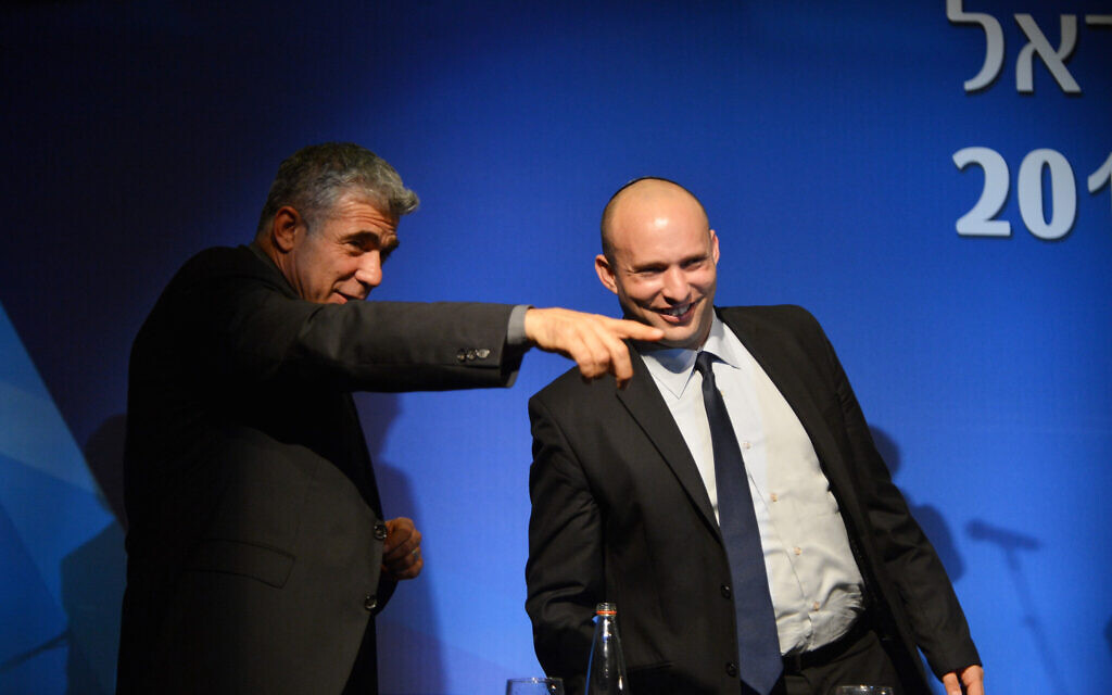 File: Then-finance minister Yair Lapid (left) and then-economy minister Naftali Bennett at the Manufacturers Association of Israel annual general assembly at the David Intercontinental Hotel in Tel Aviv, February 26, 2014. (Yossi Zeliger/Flash 90.)