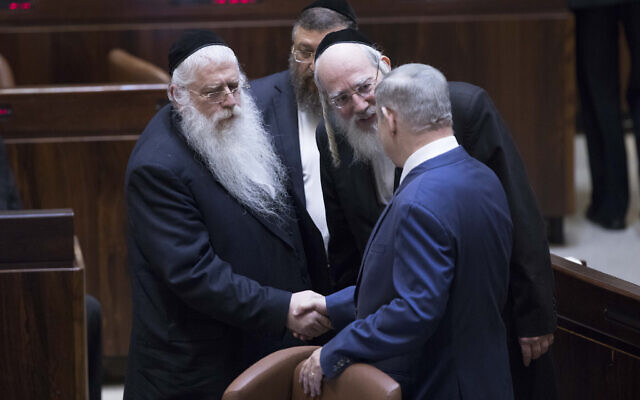 Prime Minister Benjamin Netanyahu, right, shakes hands with United Torah Judaism MKs Yisrael Eichler, center and Meir Porush in the Knesset, January 25, 2019. (Yonatan Sindel/Flash90/File)