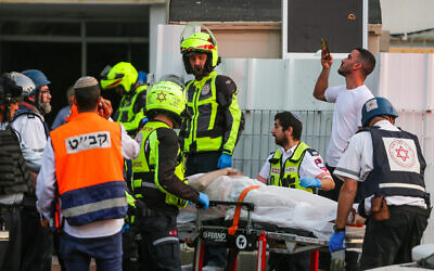 Medics evacuate an injured man at the scene where an apartment building was hit by a rocket fired from the Gaza Strip in Ashkelon, southern Israel, on May 11, 2021. (Edi Israel/Flash90)