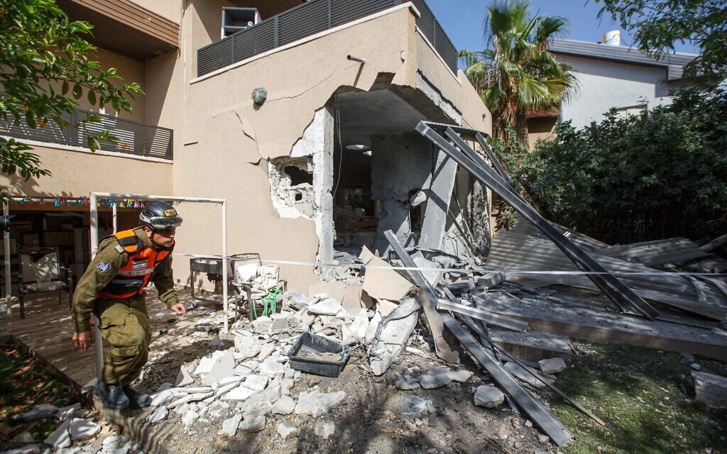 A soldier from the Israeli military's Home Front Command walks outside a house in the southern Israeli city of Ashkelon that had been struck by a Hamas rocket on May 20, 2021. (Edi Israel/FLASH90)
