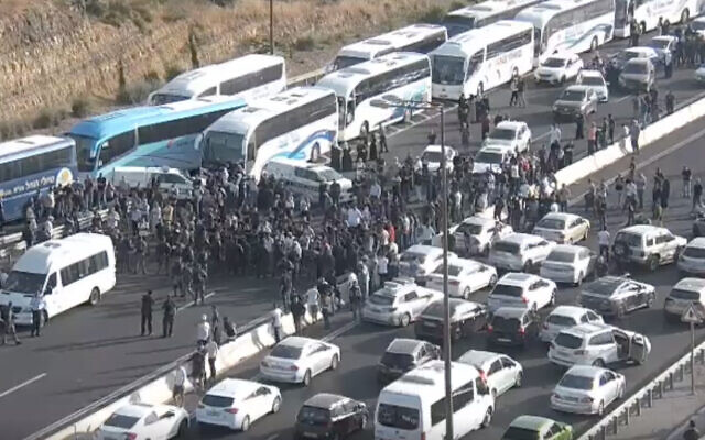 Arab Israelis block traffic on Route 1 after the buses they were traveling on were stopped en route to Jerusalem, amid rising violence in the city, on May 8, 2021. (Screen capture)