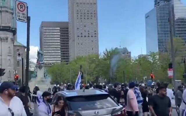 People attending an Israel solidarity rally in Montreal run as pro-Palestinian activists throw rocks at them on May 16, 2021 (Screen capture/Twitter)