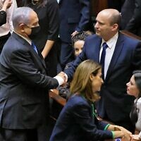 Israel's outgoing prime minister Benjamin Netanyahu shakes hands with his successor, incoming Prime Minister Naftali Bennett, after a special session to vote on a new government at the Knesset in Jerusalem, on June 13, 2021. (Emmanuel Dunand/AFP)