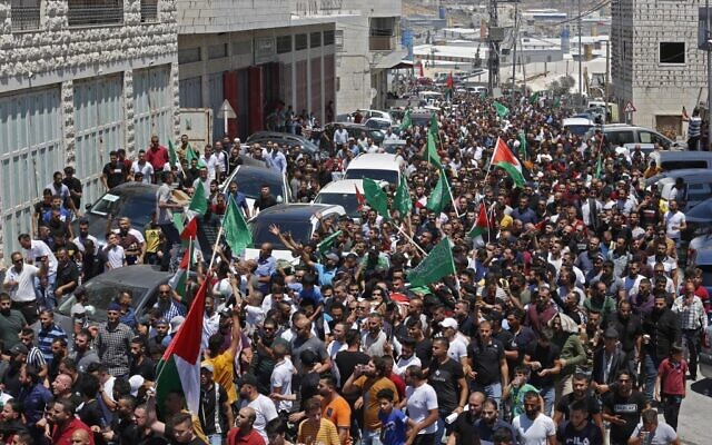 Mourners walk in a funeral procession with the body of Palestinian Authority critic Nizar Banat, who died shortly after being arrested by the PA a day before in Hebron on June 25, 2021 (Photo by MOSAB SHAWER/AFP)