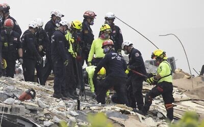 Members of the South Florida Urban Search and Rescue team look for possible survivors in the partially collapsed 12-story Champlain Towers South condo building, on June 25, 2021, in Surfside, Florida (Joe Raedle / Getty Images North America / Getty Images via AFP)