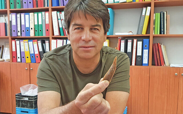 Prehistorian Dr. Omry Barzilai with a flint tool from 50,000-year-old Boker Tachtit. (Israel Antiquities Authority)