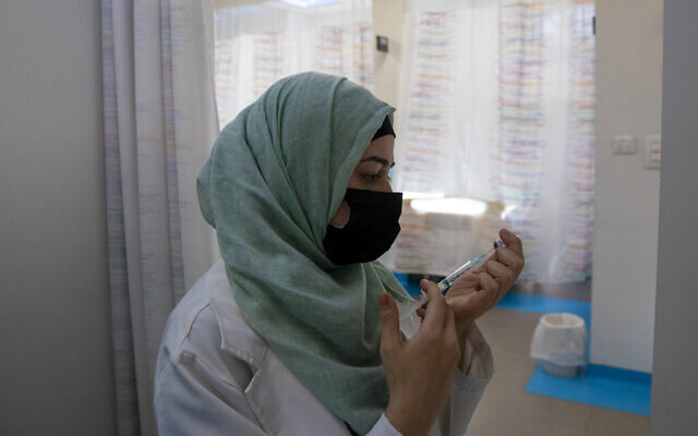 An Israeli-Arab health care professional prepares a vaccine (AP Photo/Ariel Schalit)