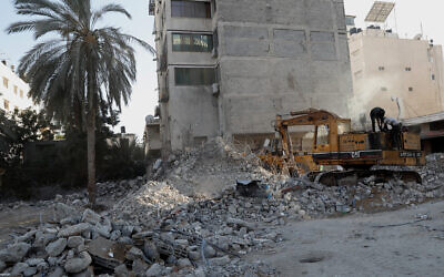 Workers remove the rubble of a building destroyed by an airstrike in Gaza City, Tuesday, June 15, 2021. (AP Photo/Adel Hana)
