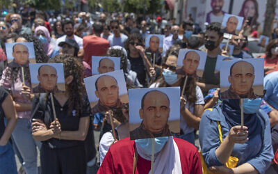 Angry demonstrators carry pictures of Nizar Banat, an outspoken critic of the Palestinian Authority, and chant anti-PA slogans during a rally protesting his death, in the West Bank city of Ramallah, on June 24, 2021. (AP Photo/Nasser Nasser)