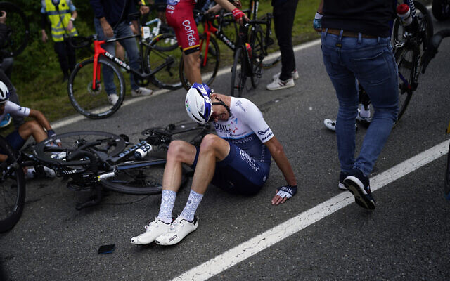Chris Froome lays on the road after crashing during the first stage of the Tour de France, on June 26, 2021. (AP Photo/Daniel Cole)