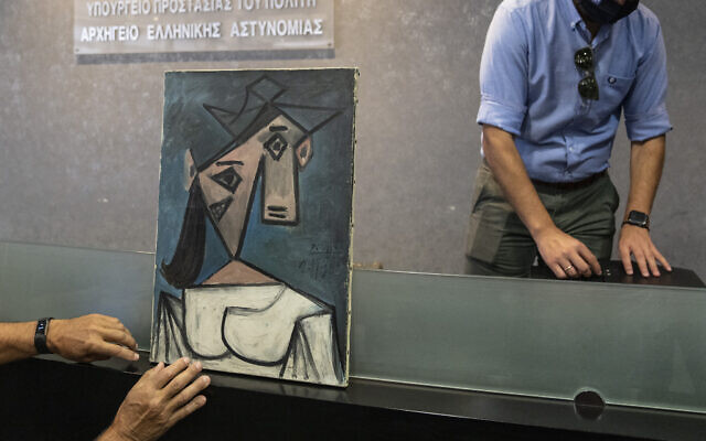 A cubist female bust by the Spanish painter Picasso is displayed by police officers in Athens during a press conference on June 29, 2021. (AP Photo/Petros Giannakouris)