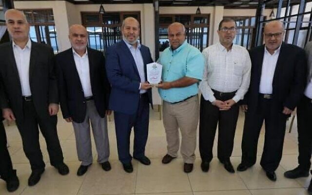 Hamas officials present Al Jazeera with a certificate after what the terror group called the outlet's 'high level of nationalism' in its coverage of last month's conflict with Israel, June 10, 2021 (via Twitter)