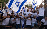 Israelis wave national flags during a Jerusalem Day march, in Jerusalem, May 10, 2021. (Nati Shohat/Flash90)