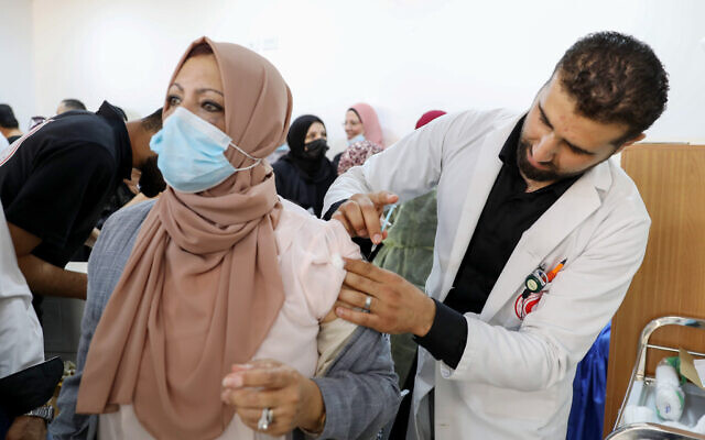 Palestinians receive the Pfizer-BioNTech COVID-19 vaccine in the West Bank city of Hebron, on March 27, 2021. (Wisam Hashlamoun/Flash90)