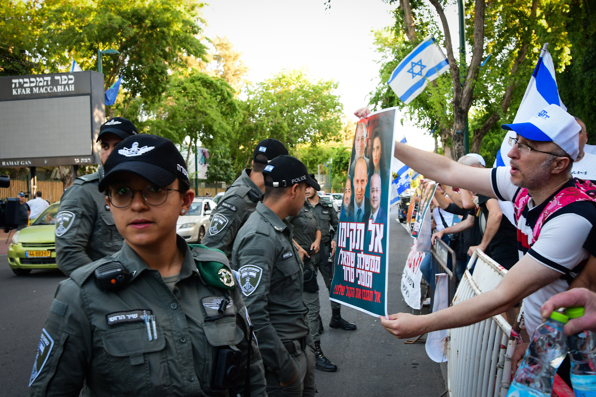 People protest against the unity government outside coalition talks at Kfar Maccabiah in Ramat Gan