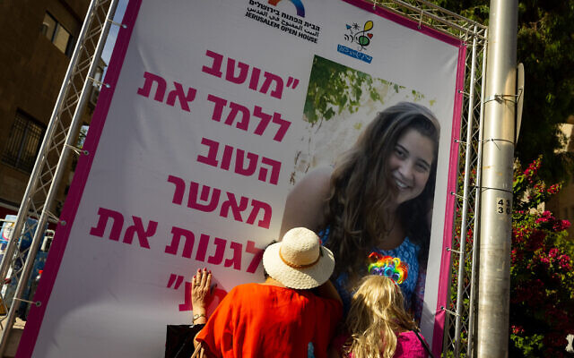 People at the Gay Pride Parade in Jerusalem on June 3, 2021 look at a photo of Shira Banki, murdered by an ultra-Orthodox extremist at the march in 2015. (Olivier Fitoussi/Flash90)
