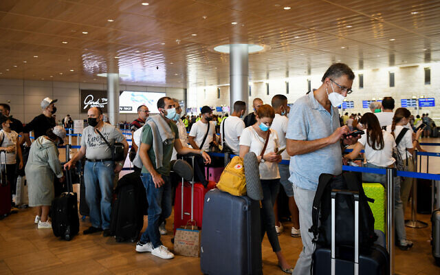 Masked travelers in the departures hall at Ben Gurion Airport on June 23, 2021. (Flash90)