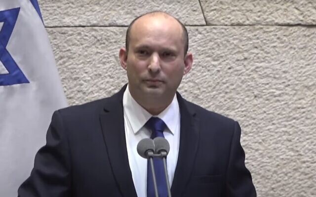 Prime Minister-designate Naftali Bennett pauses amid heckling of his speech to the Knesset, June 13, 2021 (Knesset channel screenshot)