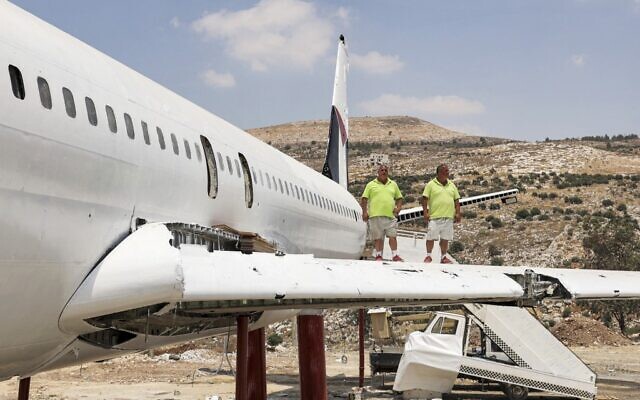 Palestinian twin brothers Atallah and Khamis al-Sairafi, 60, stand together on the wing of a Boeing 707 aircraft being converted into a restaurant near the city of Nablus in the West Bank on July 5, 2021. (Photo by JAAFAR ASHTIYEH / AFP)