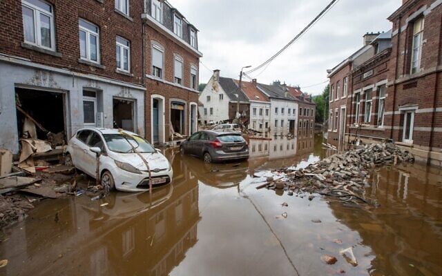 Damaged cars, debris and bricks a strewn across the street, following heavy rainfall which had caused severe flooding in the area, in Pepinster, Belgium, on 17 July 2021. (Photo by NICOLAS MAETERLINCK / BELGA / AFP)
